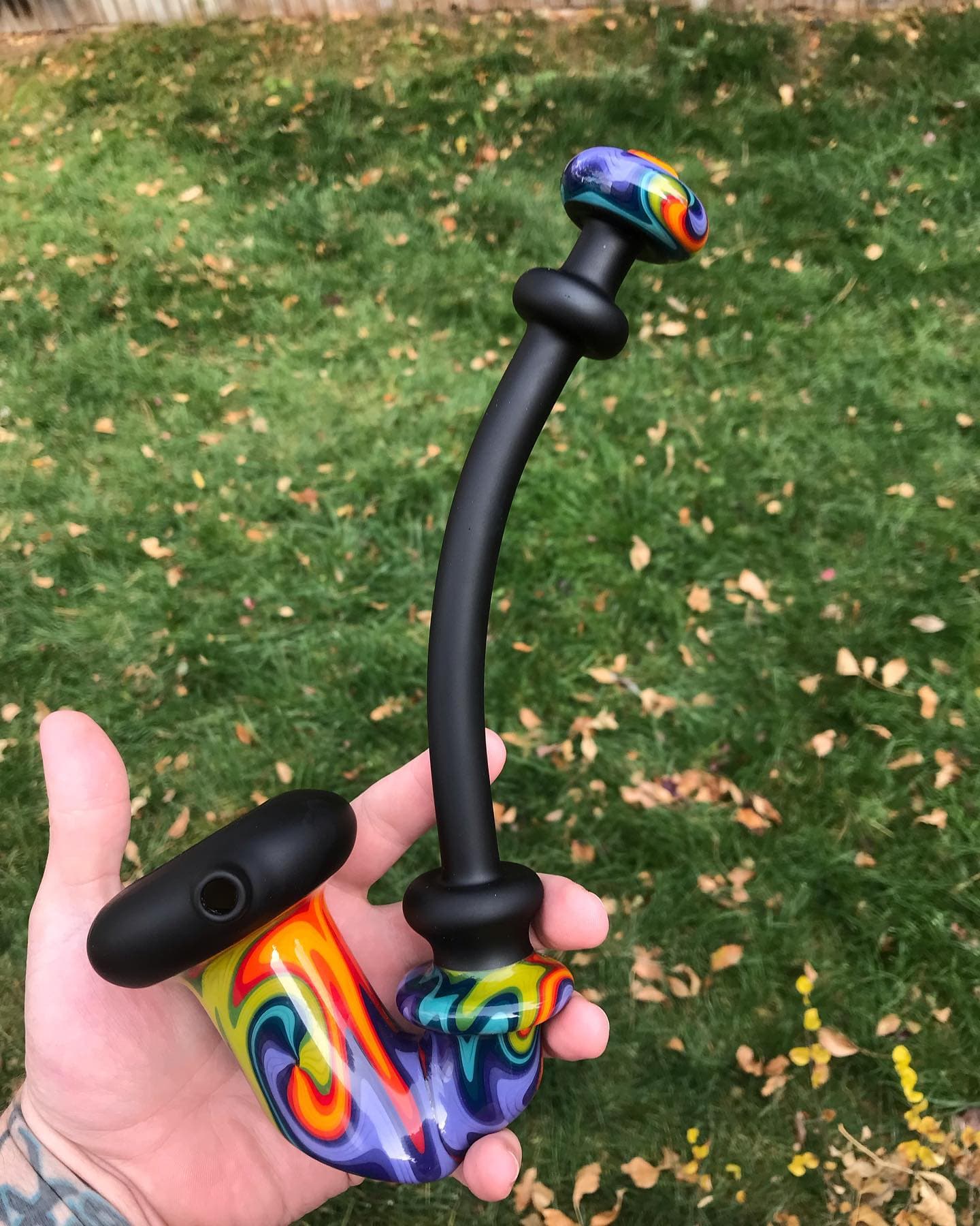 A dramatically long Sherlock-style dry pipe held in one hand for scale.