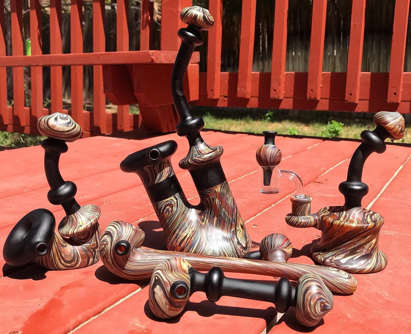 A spread of functional pieces on a deck: long pipe, bubblers, hand pipes, and a slide.