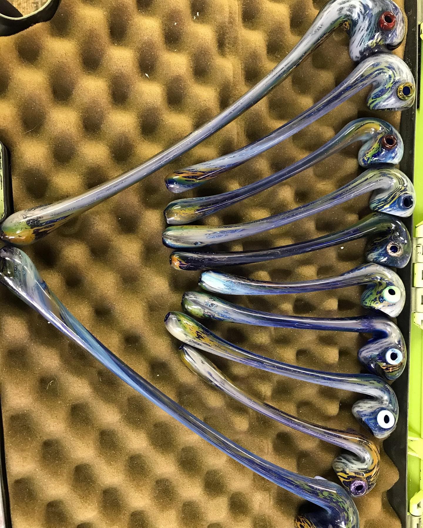A set of elongated Sherlock-style pipes packed in foam inside a hard case.
